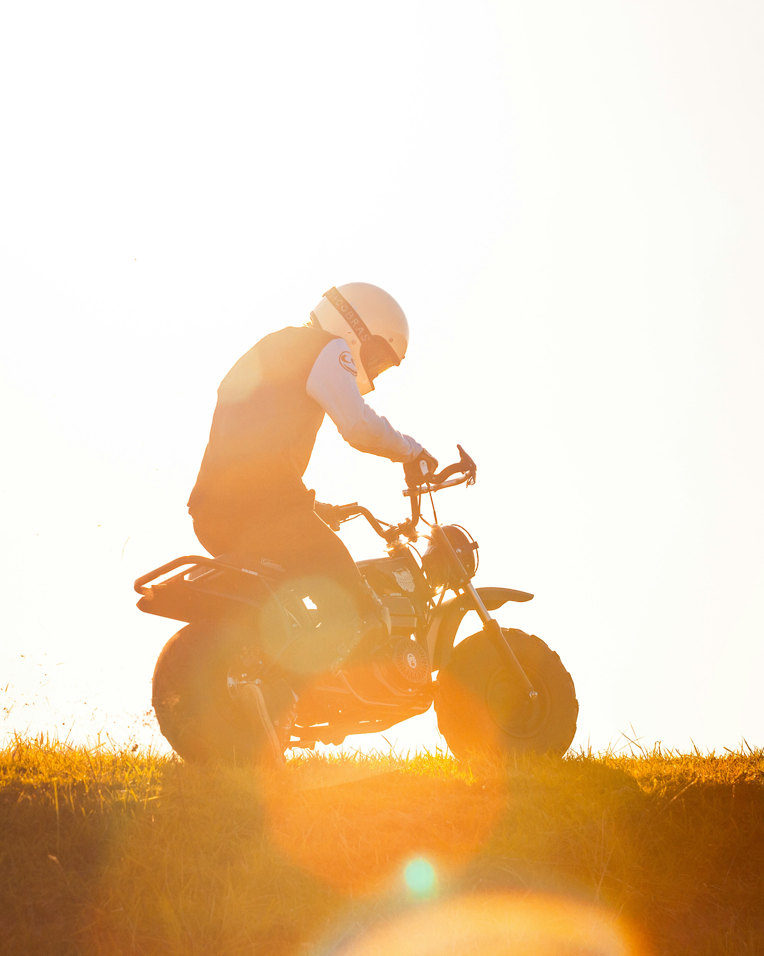 man riding motorcycle on grass field during daytime